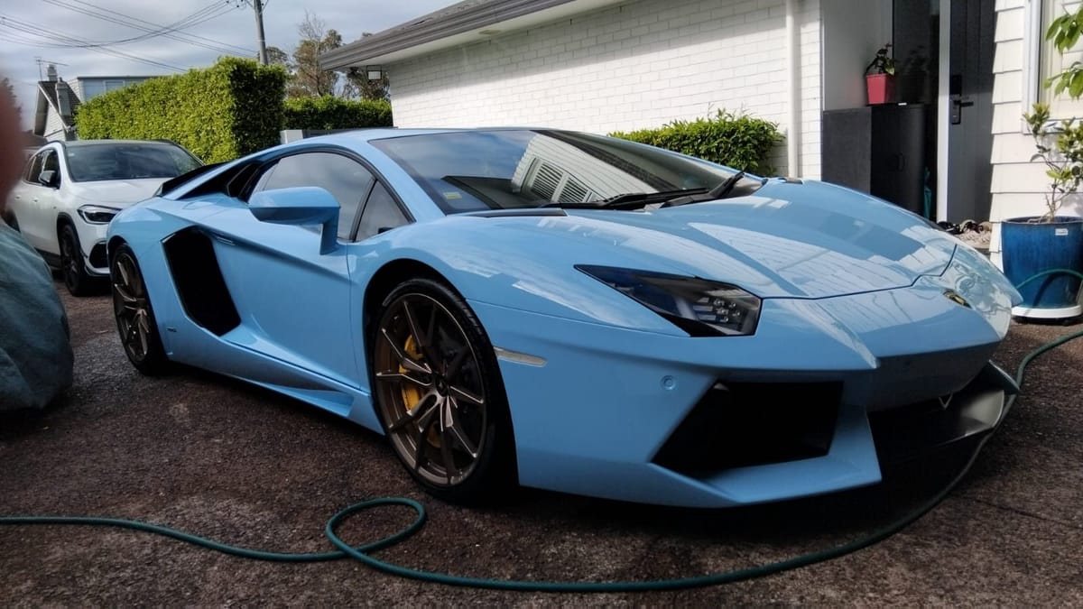 Pale blue Lamborghini Aventador, freshly detailed on a client driveway