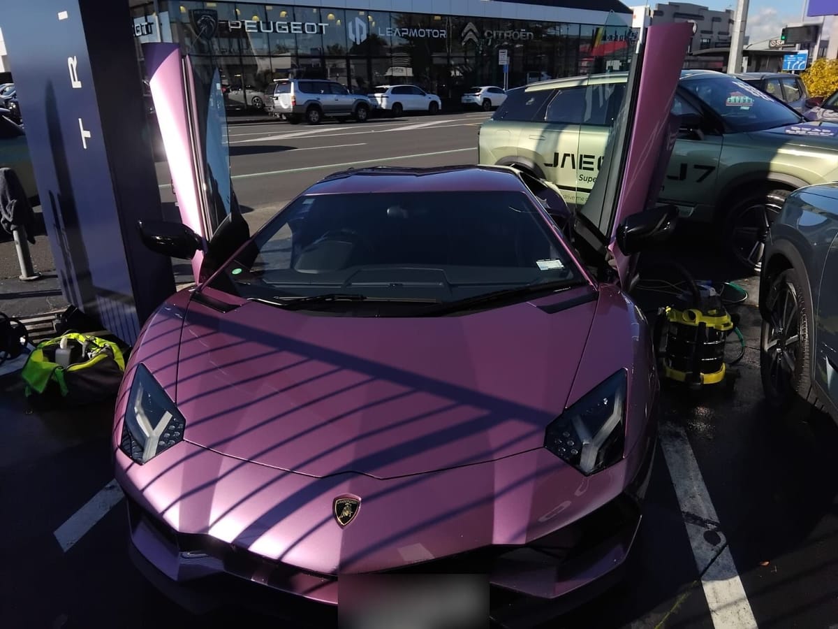 Purple Lamborghini Aventador S with its doors up, detailed on site