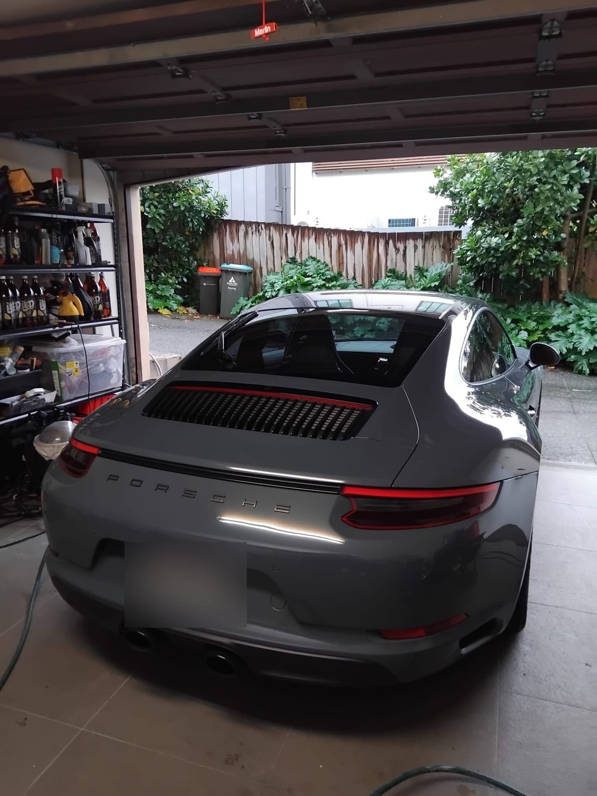 Grey Porsche 911 from the rear, gloss reflecting the garage lights